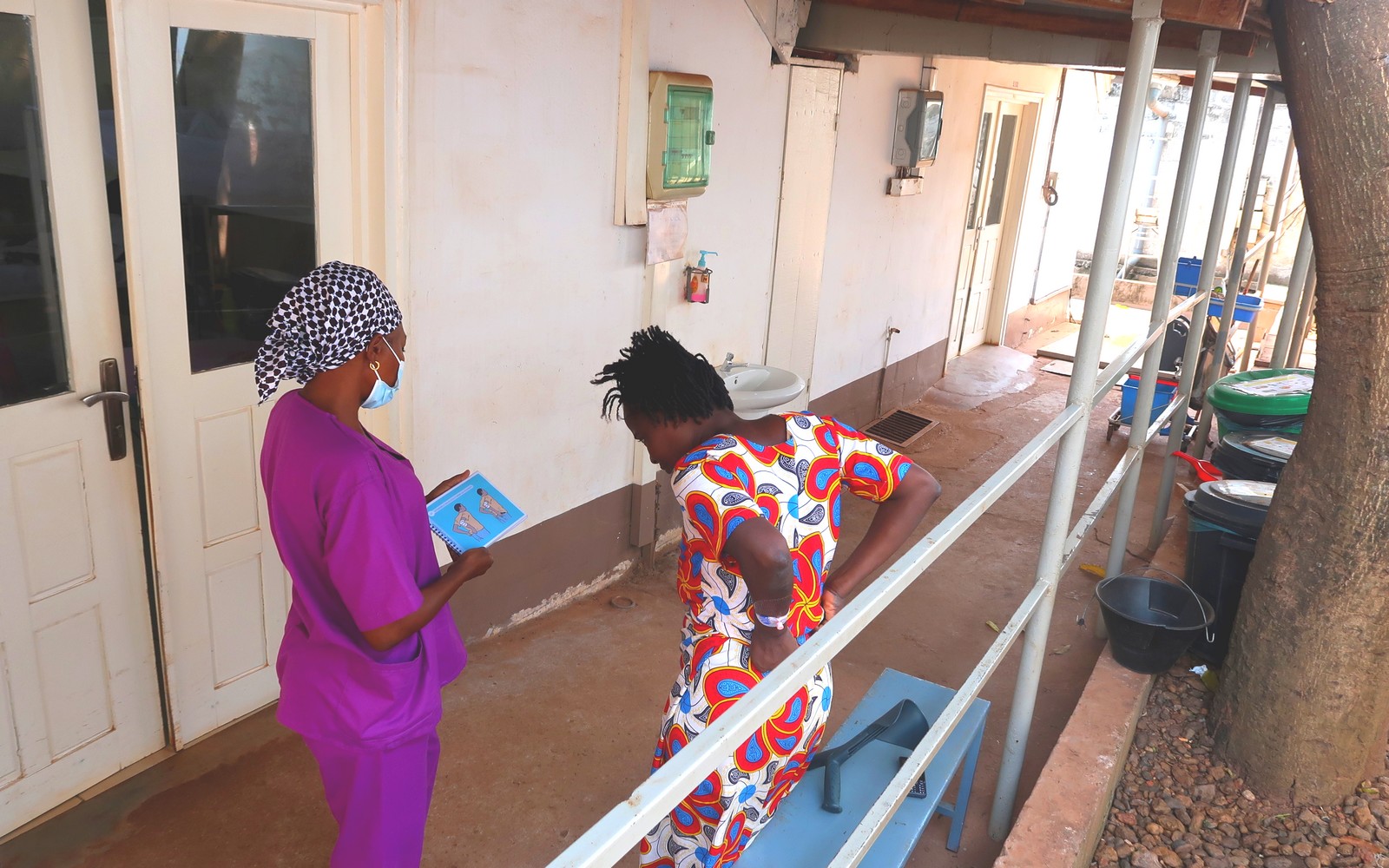 Une kinésithérapeute utilise les cartes de poche AIM-T avec une patiente pour évaluer son niveau d'indépendance après un traumatisme à l'hôpital MSF Sica à Bangui, en République centrafricaine.