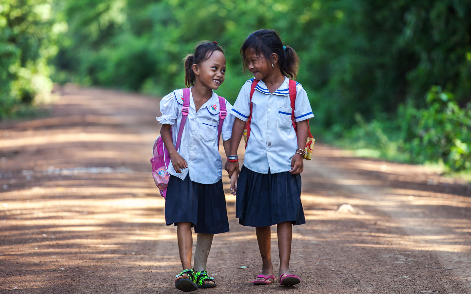 Cambodia, Kampong Champ, Channa, amputated and fitted with a prosthesis by HI, here on her way to school with a friend.