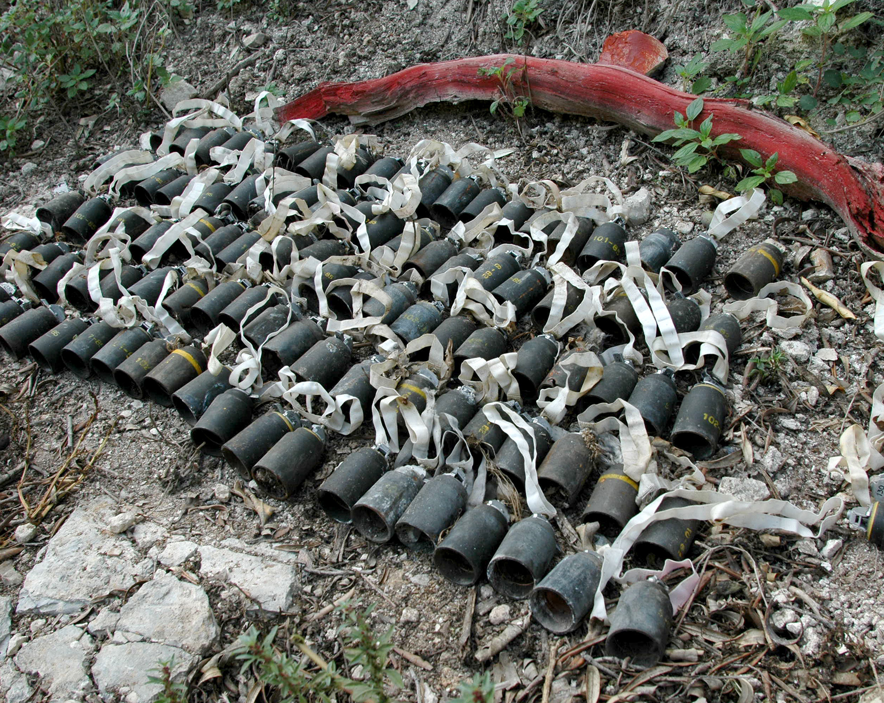 Bombes à sous munitions M85 regroupées sur le sol.