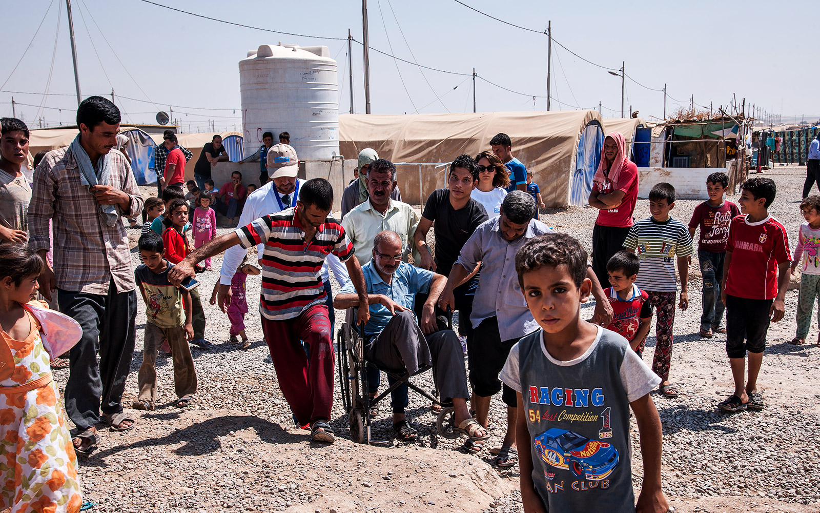 Irak, camp Khazer M1, une équipe psychosociale de HI évalue avec un bénéficiaire les difficultés pour se déplacer dans le camp avec un fauteuil roulant.