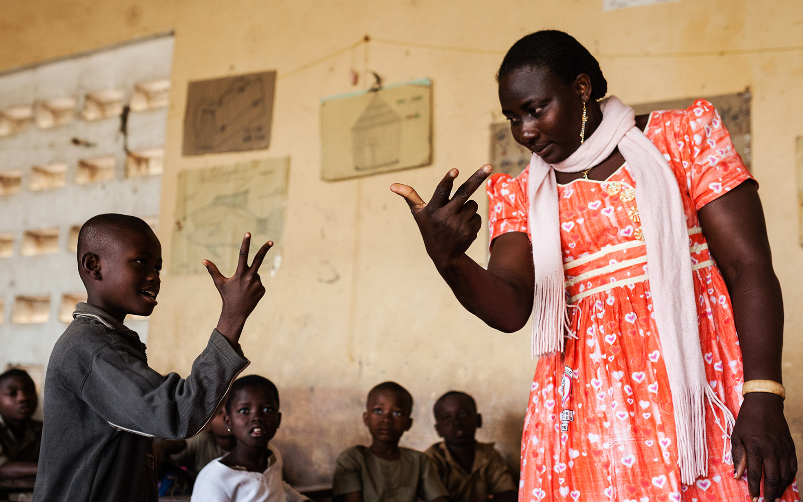 Togo, éducation inclusive. Tous les enfants de la classe, valides ou handicapés, apprennent la langue des signes. Abiré, est malentendante, elle est intégrée en milieu ordinaire.