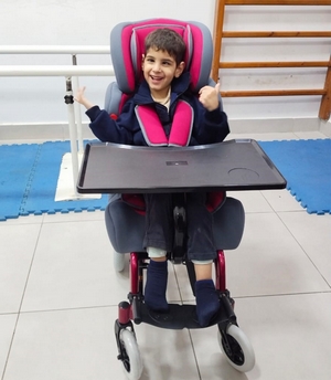 Jeune garçon dans un fauteuil adapté à son handicap
