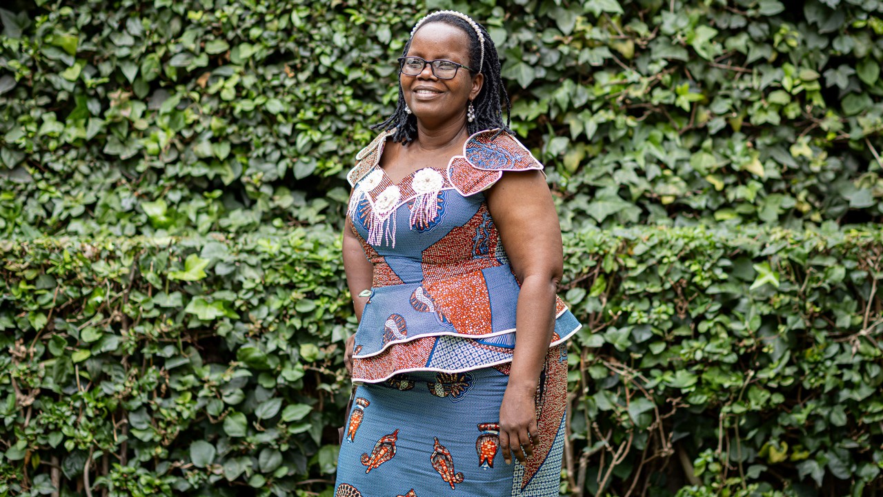 Femme souriante qui pose pour la photo dans un jardin.