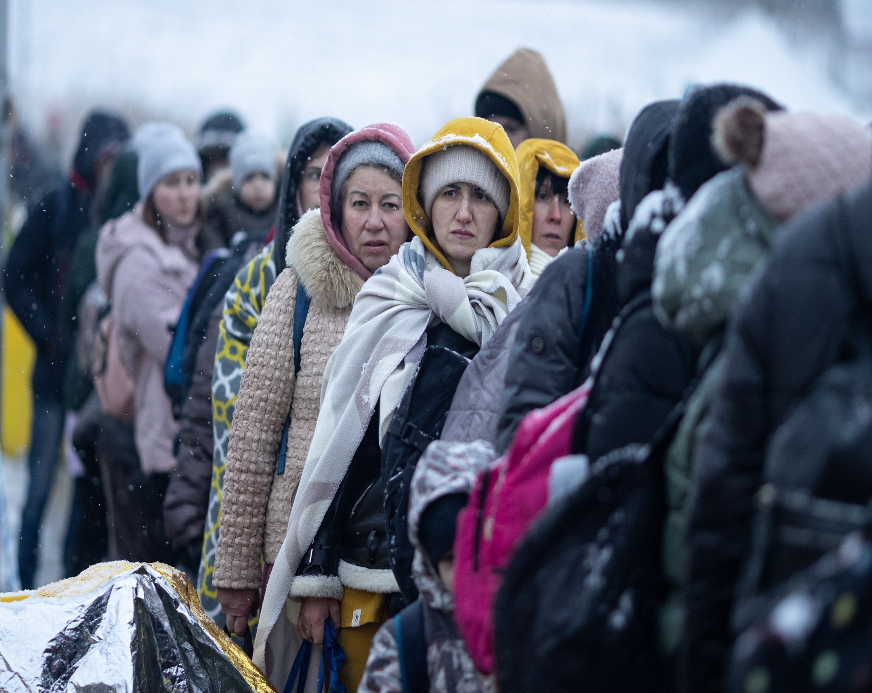 Des personnes traversent le poste frontière de Medyka, entre l'Ukraine et la Pologne.