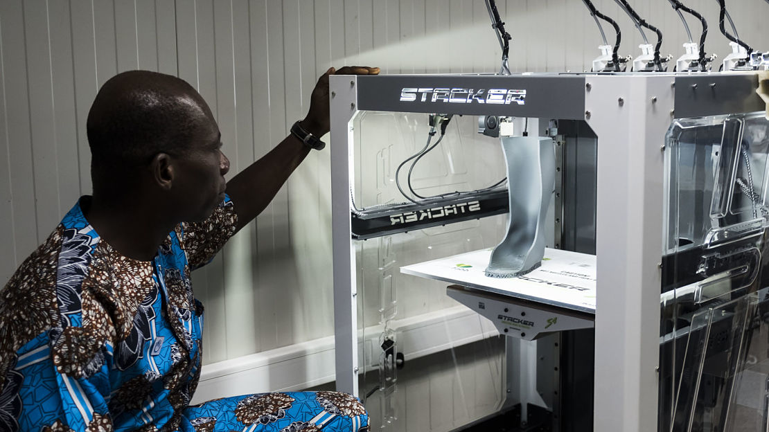 A technician follows the printing of a 3D orthosis in Lomé, Togo