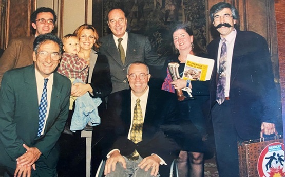 Palais de l'Élysée, septembre 1998. Autour du Président Jacques Chirac, de gauche à droite : Philippe Chabasse, Xavier Emmanuelli, Patrick Segal (en fauteuil roulant), sa femme Hélène et son fils Victor, Susan Walker et Jean-Baptiste Richardier. © Présidence de la République, 26 septembre 1998