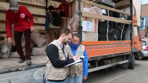 HI emergency staff, Oleksi Torvkis  (left) and Yolene Joly (right) oversee the delivery of bed kits to collective centers housing displaced persons in Ukraine. ; }}