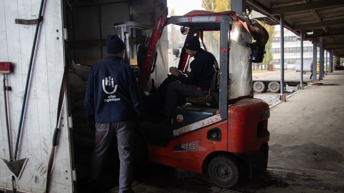 Des agents d’Atlas Logistique charge des briquettes de combustible solide dans un camion en novembre 2024 à Dnipro, dans l’Est de Ukraine. ; }}