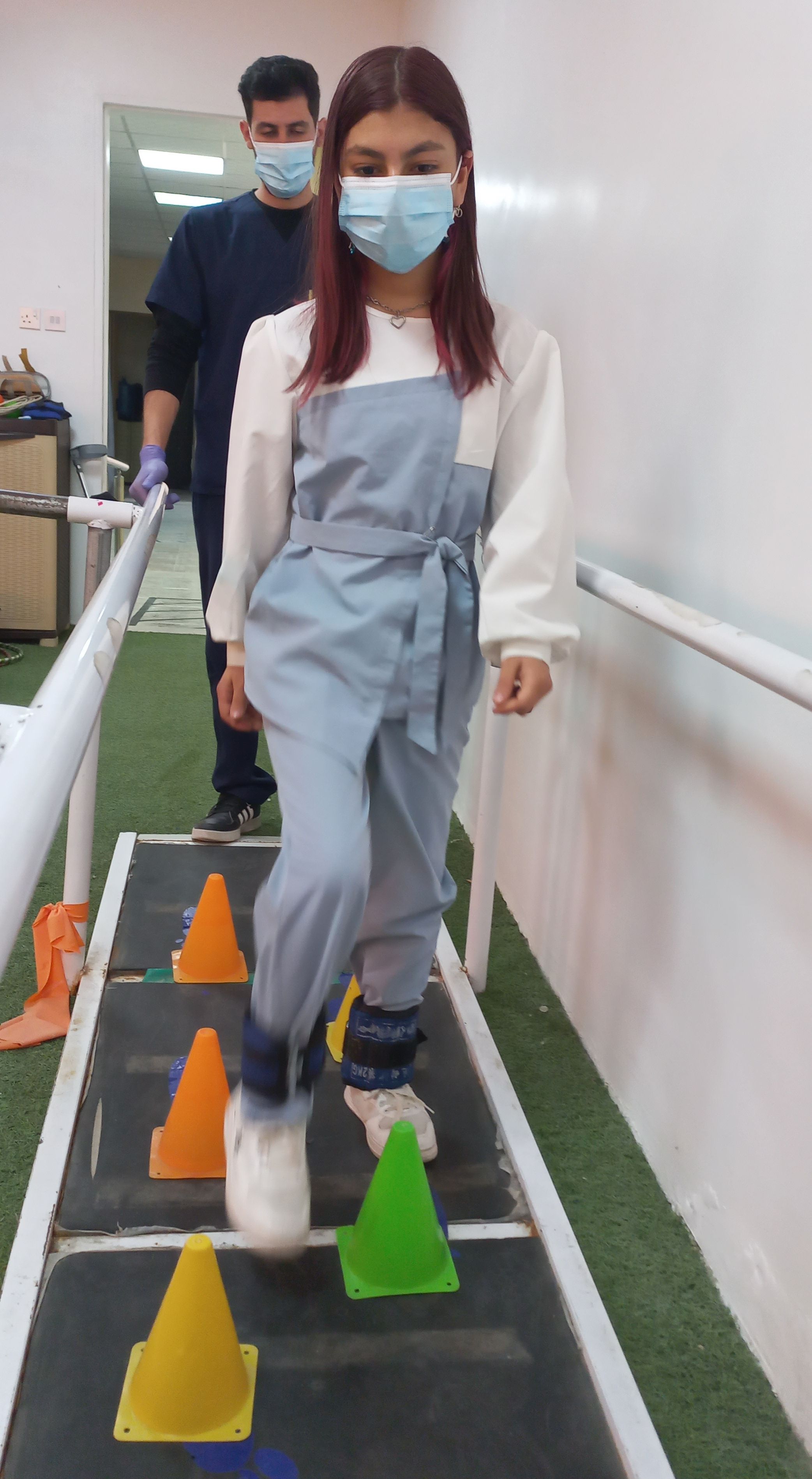 Gina pendant une séance de réadaptation, réalisant un exercice de parcours d'obstacles.