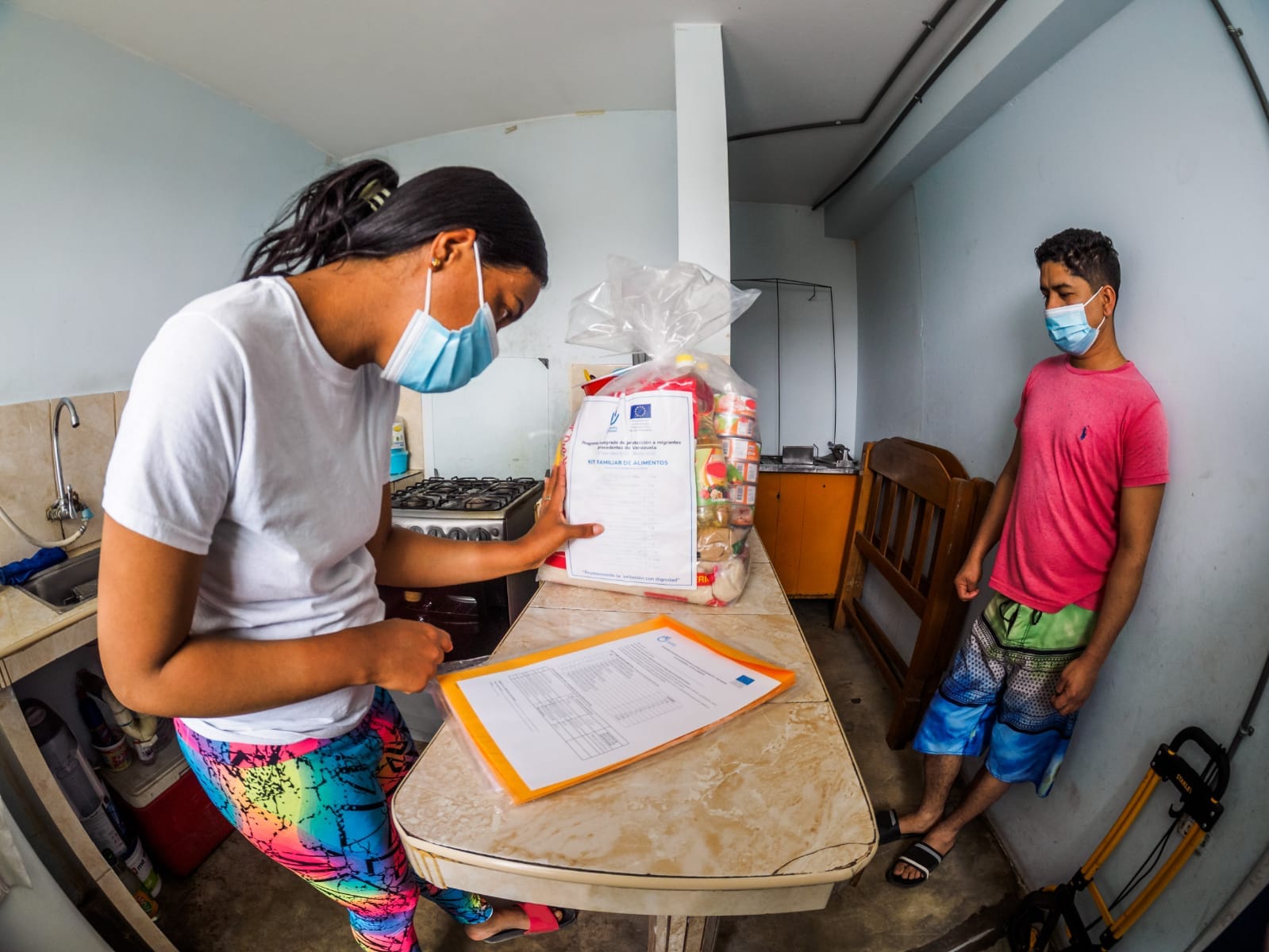 Clara and Juan looking at their food basket donated by HI.