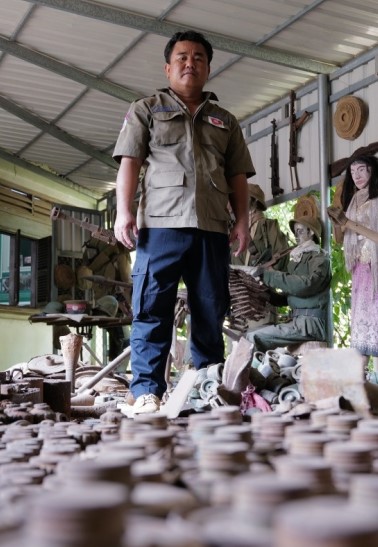 Aki Ra in front of landmines