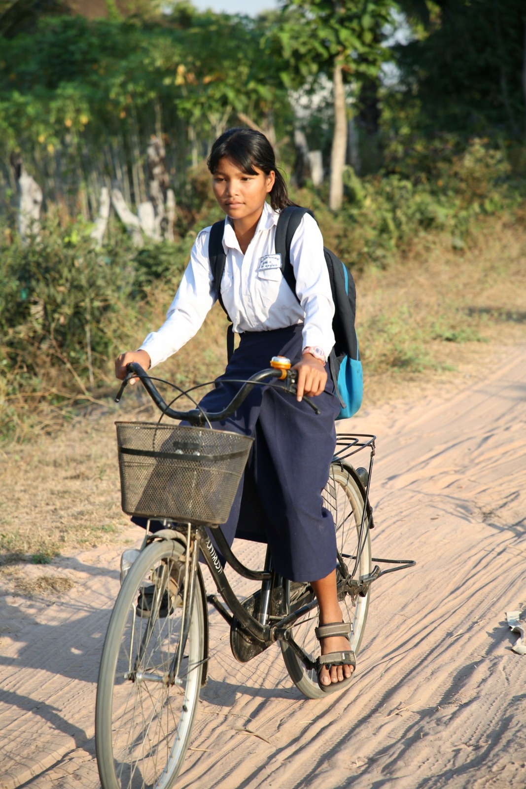 A young girl fitted with prosthesis is riding her bicycle 