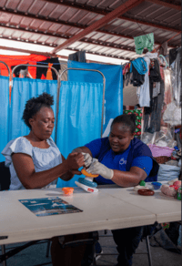 Eugénie Laventure does hand flexibility exercises with Gaëlle Charles, a HI physiotherapist. © T. Noreille / HI