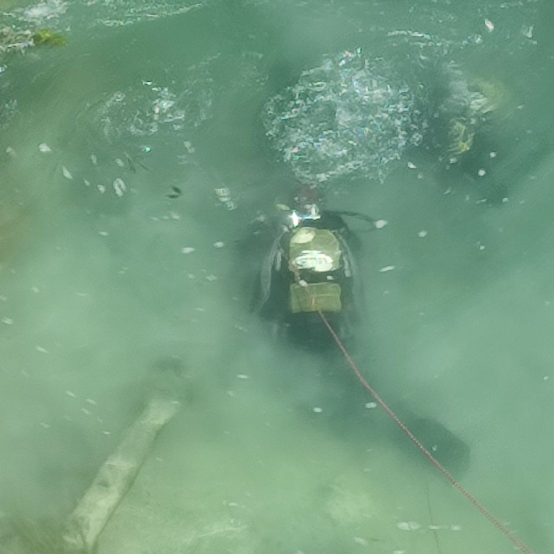 Plongeur sous-marin spécialisé en déminage en train de chercher des engins explosifs dans une rivière.