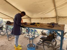 A technical aid worker fabricates and repairs mobility aids at a prosthetics and orthotics workshop at the Kakuma Refugee Camp in Kenya. © E. Sellers / HI