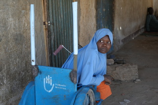 Roumanatou dans le tricycle qui lui a été donné par HI. © J. Labeur / HI