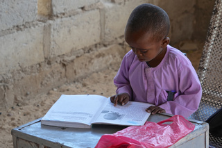 Mahamadou révise ses cours à la maison et fait ses devoirs pour le lendemain. © J. Labeur / HI