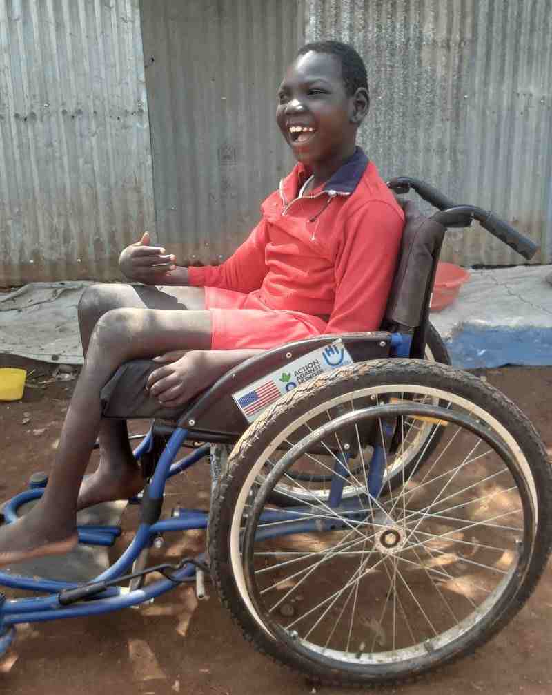 Omod utilise son nouveau fauteuil roulant donné par HI