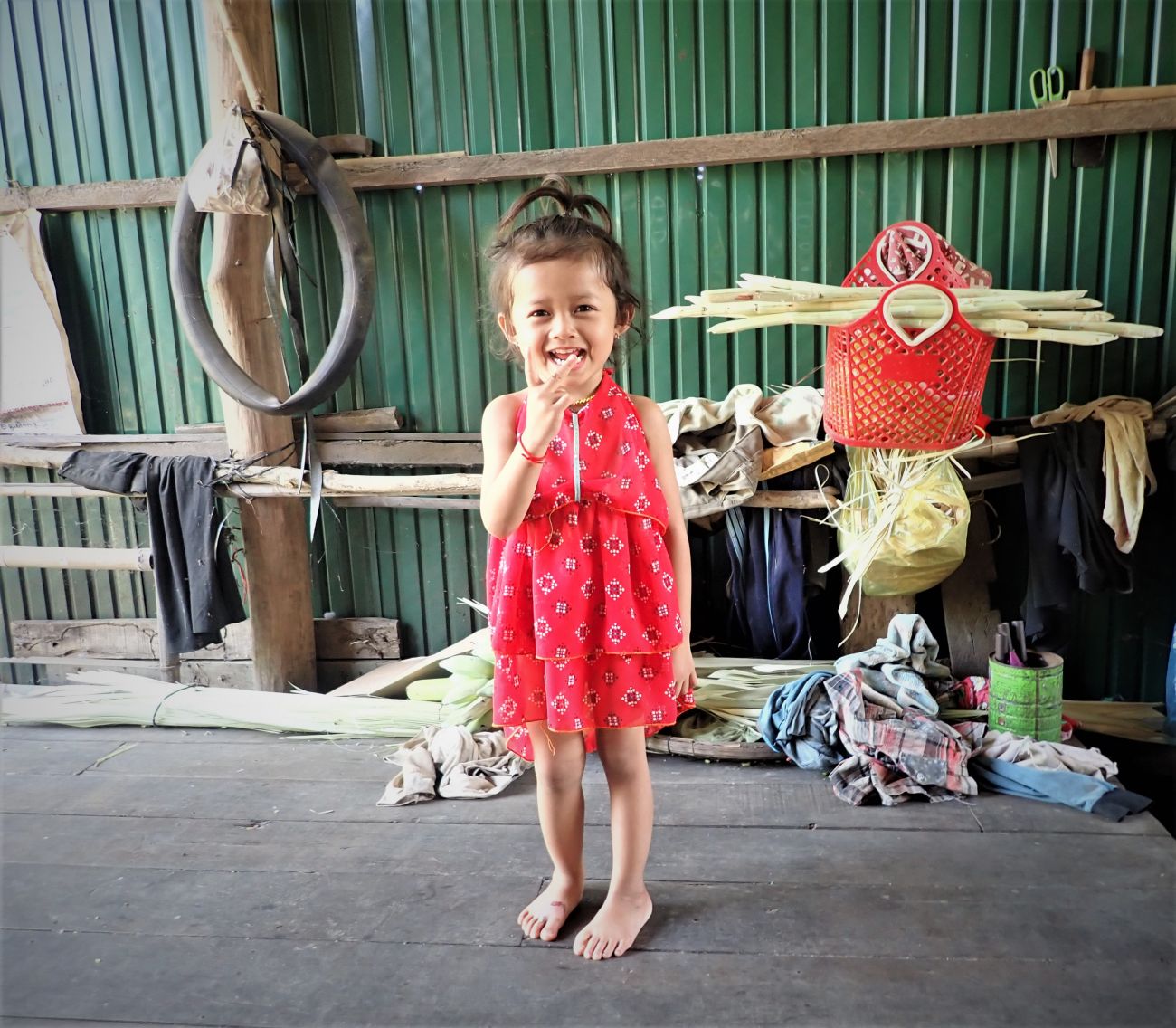 Grâce au dépistage précoce de HI, le pied bot de Un Sonita a été identifié très tôt. Petite fille qui pose pour la photo en robe rouge