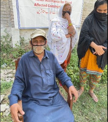 A man who lost his home in the floods. He is sitting in a chair, wearing a face mask. © HI