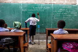 Raphaël writes on the board during a maths lesson in Selembao inclusive school. © T. Freteur / HI