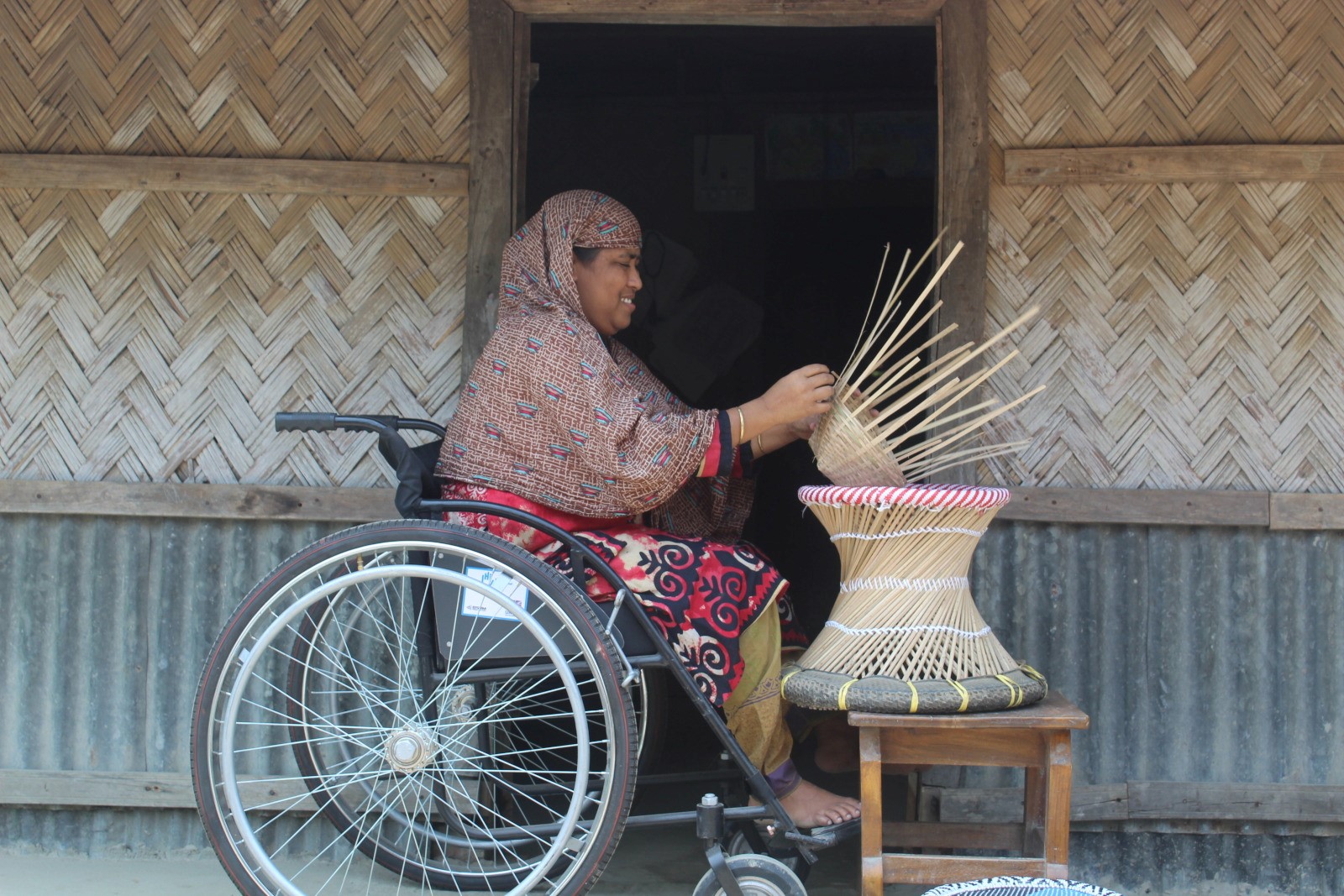 Sanowara B., 35, works in basket weaving in Bangladesh. 2021 © HI