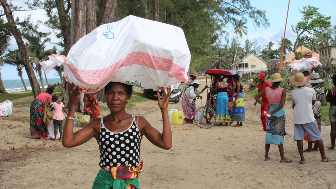 A woman is carrying a white bag with the HI logo; }}