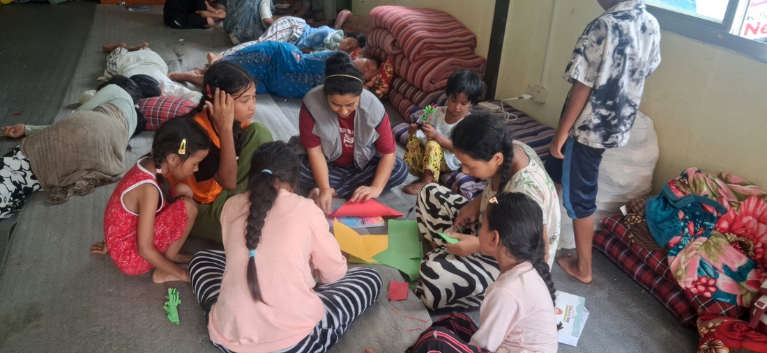 A group of children are sitting in a circle and taking part in a creative activity.; }}