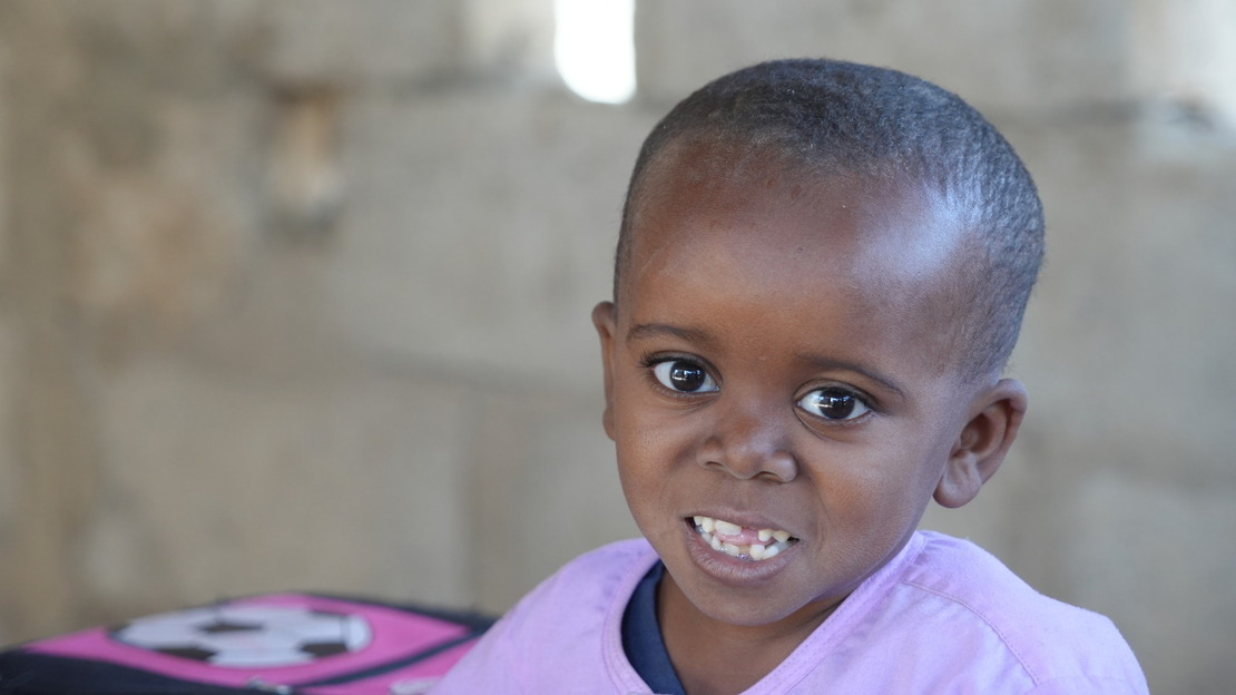 Portrait of Mahamadou, looking and smiling at the camera.; }}