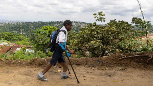 Raphaël sur le chemin de l’école inclusive de Selembao, RDC. ; }}