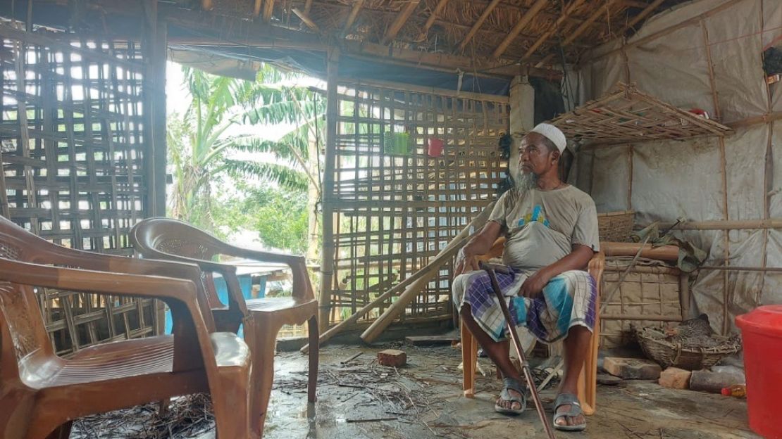 Un homme assis dans sa maison endomagée; }}