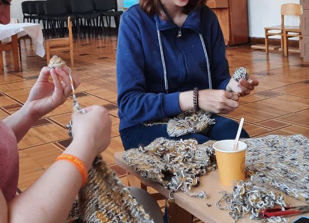 Women participate in a knitting group in a collective center. 