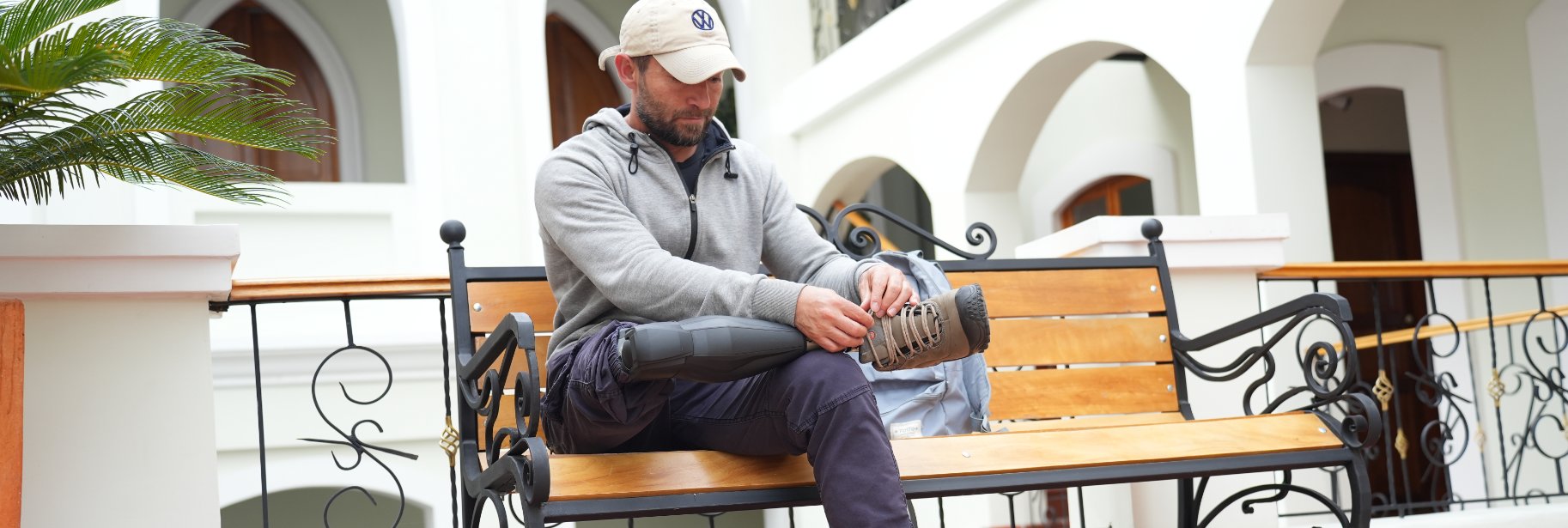 Andres sitting on a bench with his prosthetic leg visible.
