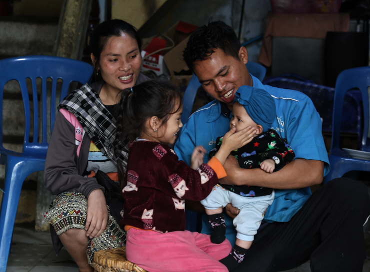 A family composed of a man, a woman and two children are sitting.