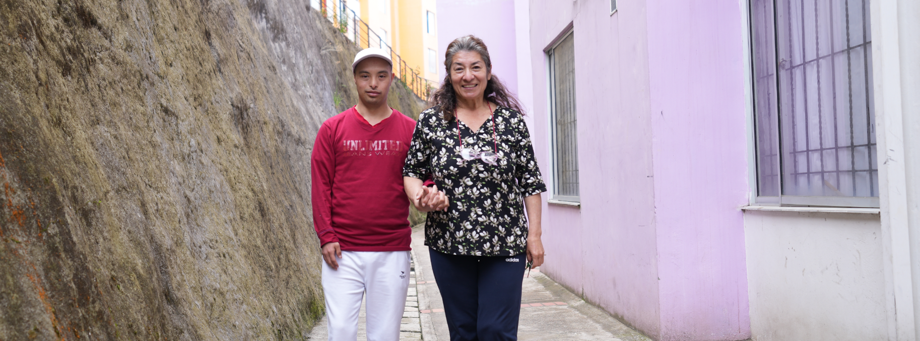 Gloria and her son holding hand in the street.
