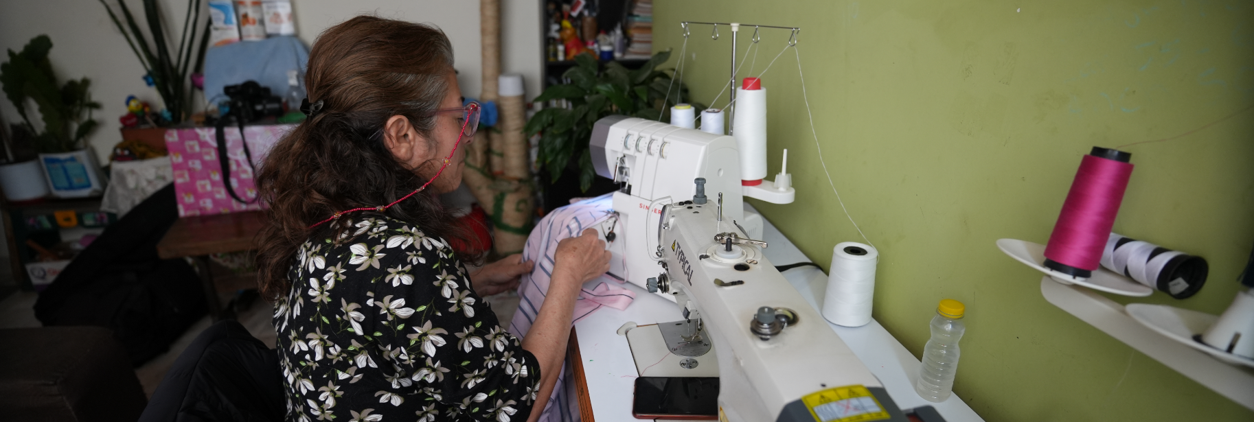 Gloria sewing on a sewing machine.