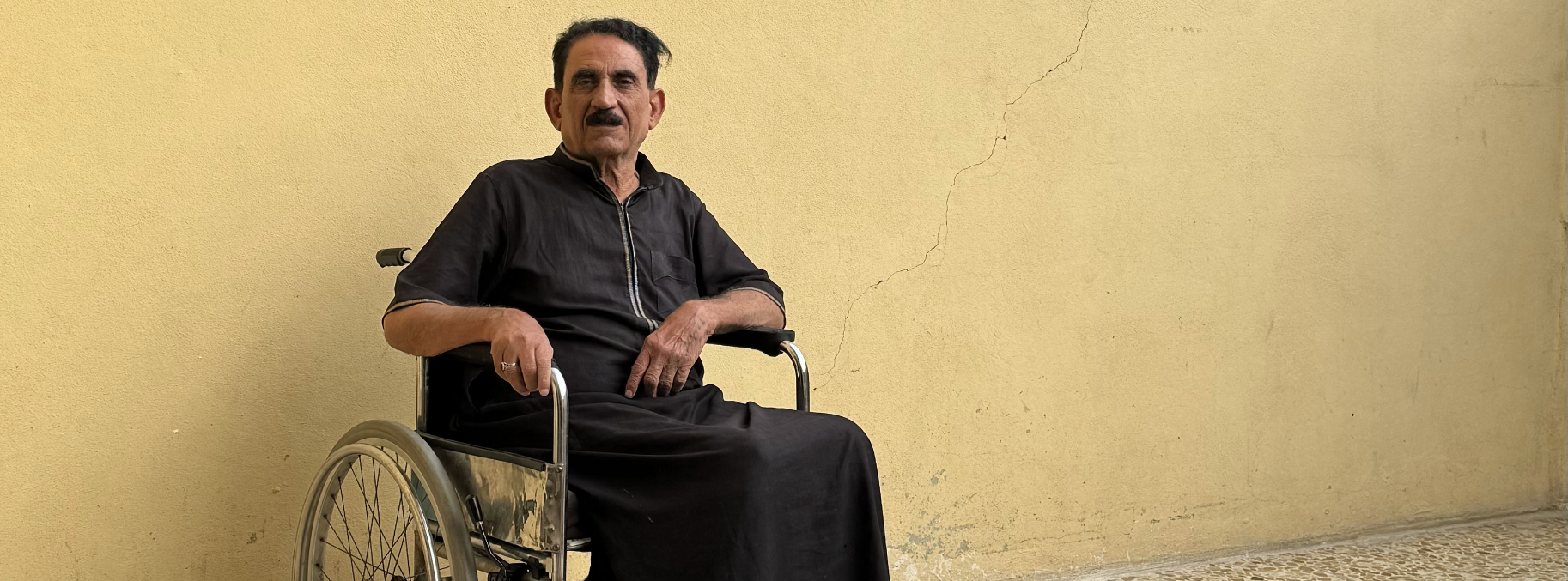 Hmoud, sitting in a wheelchair, in the patio of his house.