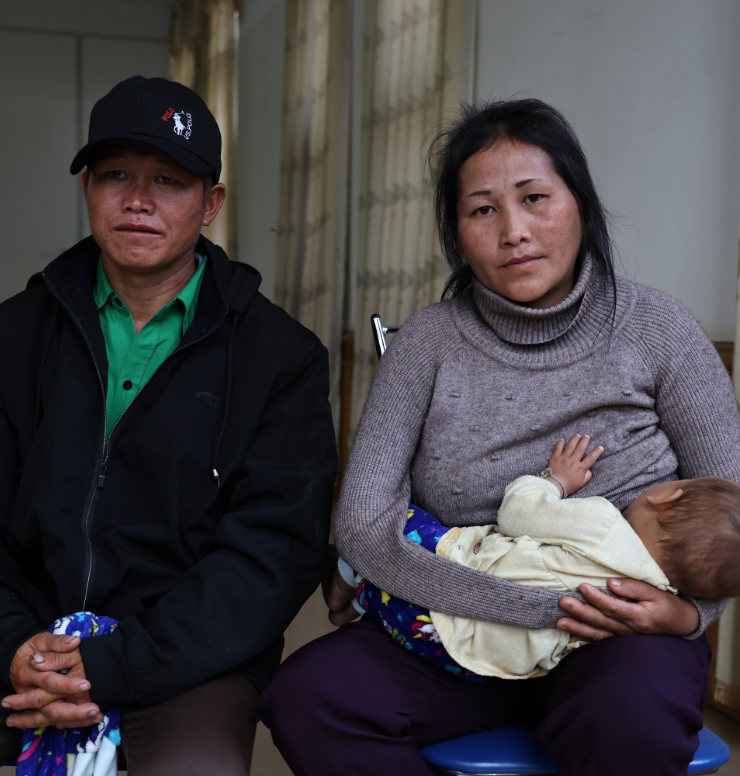 Mrs Xoua and her husband holding their baby.